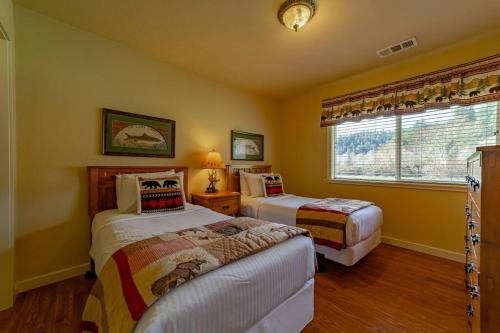 1 Schlafzimmer mit 2 Betten und einem Fenster in der Unterkunft Elk Meadow Cabins 13A Bears Den Suite in Orick