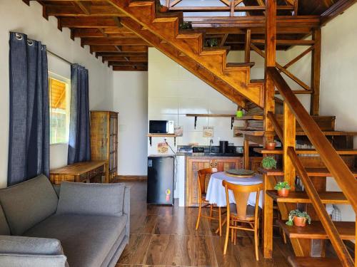uma sala de estar com um sofá, uma mesa e uma cozinha em Villa Park Chalés - A sua fazendinha ao lado do Beto Carrero em Penha