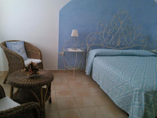 una camera da letto con un letto, una sedia e un tavolo di B&B da Anna a Bosa