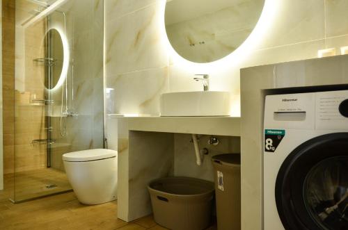 a bathroom with a sink and a washing machine at Verga Paradise Nest - A Blissful Hideout in Almirón