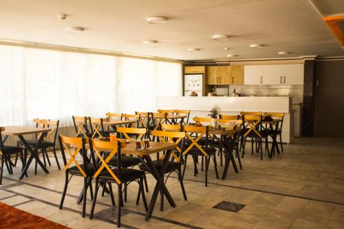 una sala da pranzo con tavoli e sedie e una cucina di Ephesus Hera a Selçuk