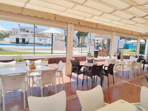 un ristorante con tavoli bianchi e sedie bianche di Duplex Las Torres La Barrosa 3Beds - A 700m de la playa a Chiclana de la Frontera