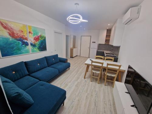 a living room with a blue couch and a table at Joanna Suites in Sarandë