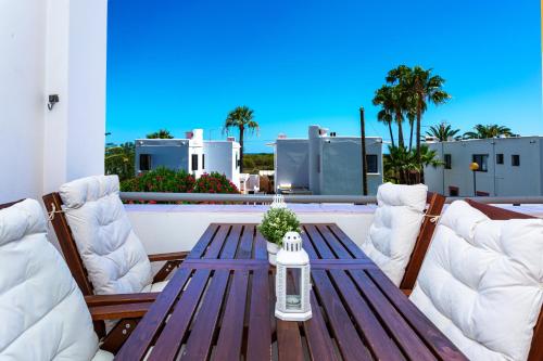 a wooden table and chairs on a patio at Cabanas Sea View APT in Golden in Cabanas de Tavira