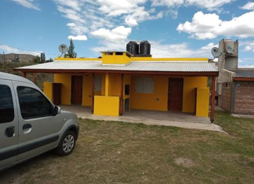 uma carrinha estacionada em frente a uma casa amarela em AIMA em Villa Giardino