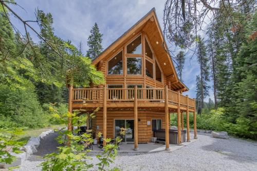 a cabin in the woods with a large window at Bearfoot Chalet by NW Comfy Cabins in Leavenworth