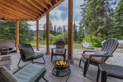 eine Terrasse mit Stühlen und einer Feuerstelle in der Unterkunft Bearfoot Chalet by NW Comfy Cabins in Leavenworth