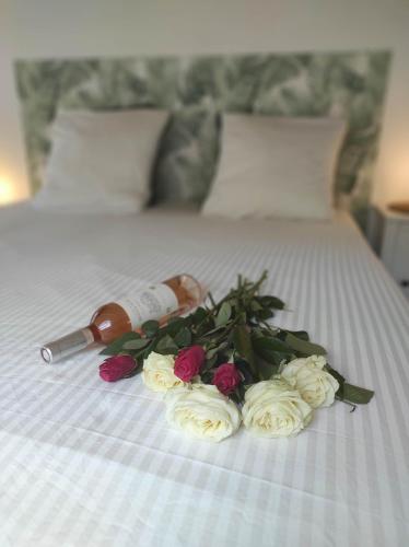 Una botella de vino y flores en una cama en Chill Out Cabanon Coeur Calanques en Marsella