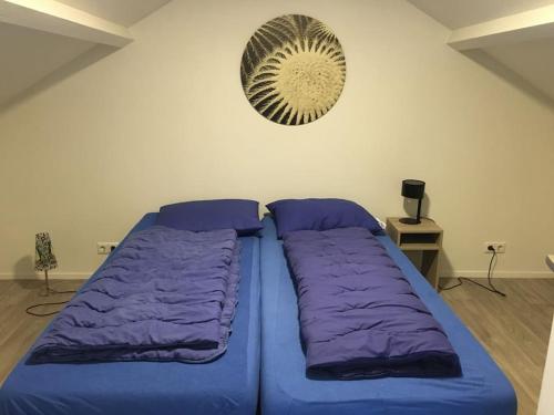 Cama con sábanas moradas en una habitación con ventilador en Adorable two bedroom bungalow C7 next to hotel. en Garderen