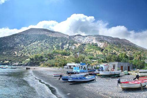 a group of boats on a beach with a mountain at Villa Crimi in Vulcano