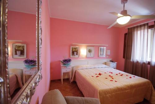 a bedroom with a bed and a mirror at Hotel Barsalini in SantʼAndrea