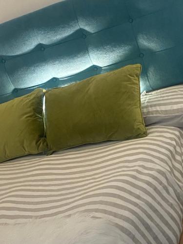 Una cama con dos almohadas amarillas encima. en Casa Vittorio, en Turín