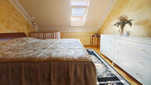 a bedroom with a bed and a dresser and a window at Family apartment 'Sofia' in Brežice
