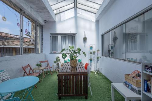 a room with tables and chairs and a table with a plant at Travel & Live Hostel in Porto