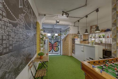 a kitchen with a chalkboard wall and green carpet at Travel & Live Hostel in Porto