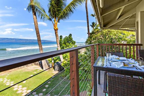 a balcony with a table and a view of the ocean at Hale Kai 220 in Kahana