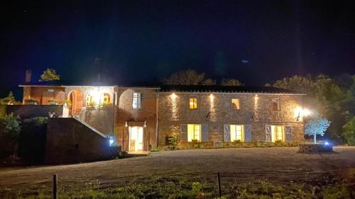 a large stone house with lights on it at night at Locanda Granducato in Chiusi