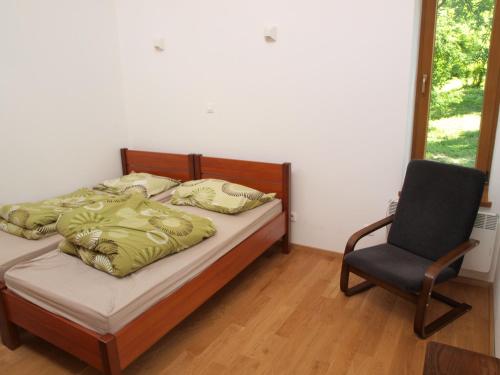 a bedroom with a bed and a chair and a window at Lake House in Kościan