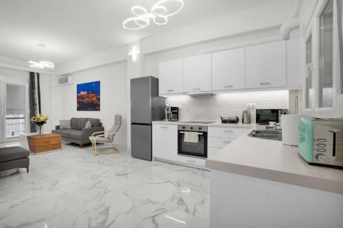 a kitchen with white cabinets and a living room at Athenian Destiny Suite in Athens