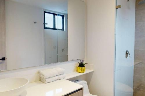 a white bathroom with a sink and a shower at 902 Cityscape Loft in Bogotá