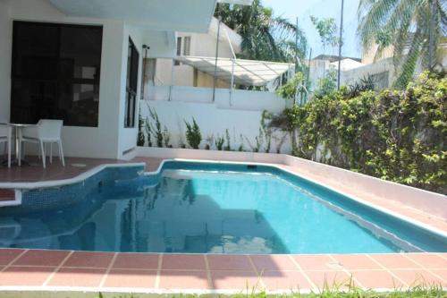 a swimming pool in front of a house at Beautiful Jungle House on a strategic location in Cancún