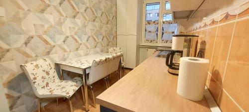 a kitchen with a counter with two chairs and a table at Central Park Apartments in Piatra Neamţ