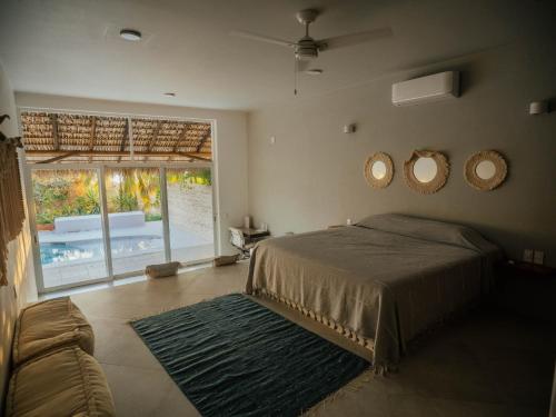 a bedroom with a bed and two mirrors on the wall at Casa La Bomba in Puerto Escondido