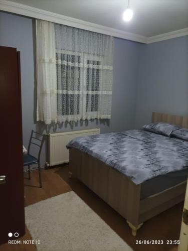 a bedroom with a bed and a chair and a window at Goldwinn turizm in Trabzon