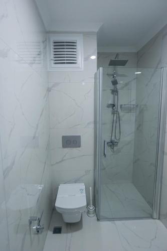a white bathroom with a shower and a toilet at THE DECK OTEL in Trabzon