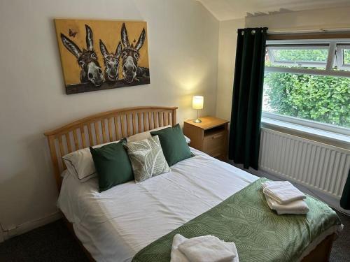 a bedroom with a bed with green pillows and a window at Entire Home in Middlesbrough