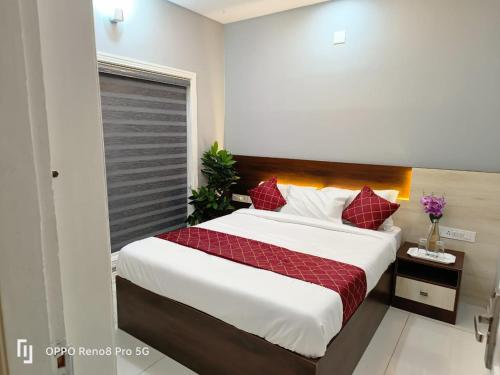 a bedroom with a large bed with red pillows at Peppercorn Cottage, Vythiri. in Vythiri