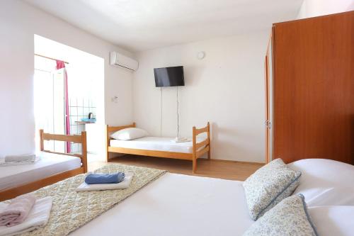 a bedroom with two beds and a tv on the wall at Studio Gradac 2784d in Gradac