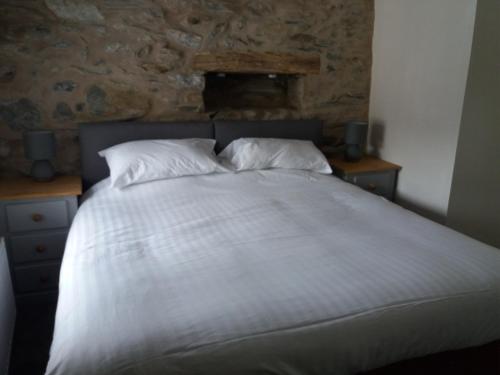 a bed with white sheets and pillows in a bedroom at NEWFIELD INN in Broughton in Furness