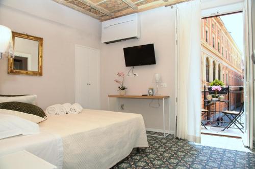 a bedroom with a bed and a tv and a window at Alle Absidi della Cattedrale in Palermo