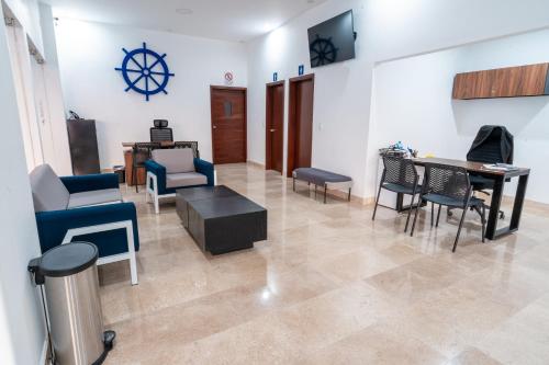 sala de estar con sillas, mesa y comedor en Hotel Pacific Blue Mazatlan en Mazatlán