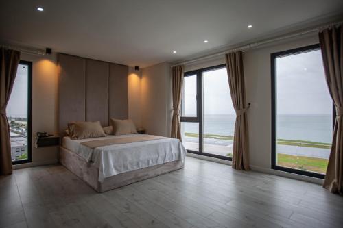 a bedroom with a large bed and large windows at THE DECK OTEL in Trabzon