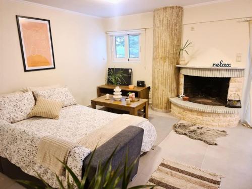 Filoxenia Luxury Home Patras في باترا: غرفة نوم بسرير ومدفأة