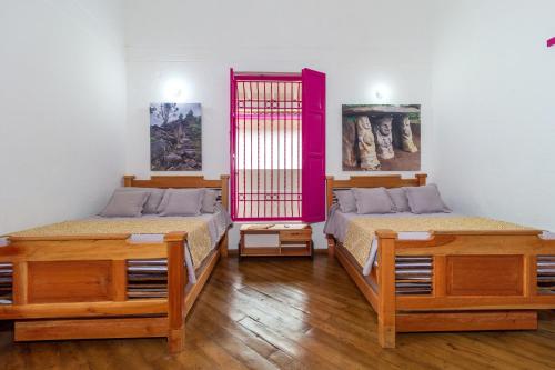 a room with two beds and a pink partition at Casa Etnika in Jericó