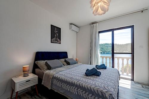 a bedroom with a bed and a large window at Apartments by the sea Ubli, Lastovo - 16599 in Lastovo