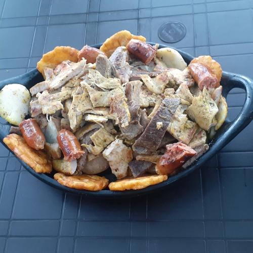 a pan filled with meat and pretzels and potatoes at Glamping eco descanso la vega Nocaima in Nocaima