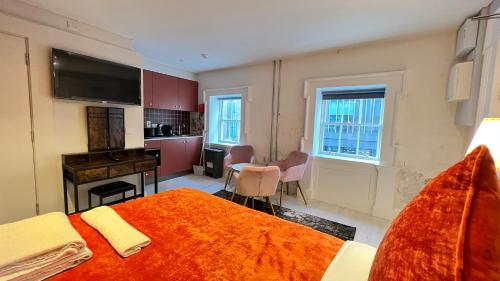 sypialnia z dużym łóżkiem i pomarańczowym kocem w obiekcie Merrion Square Studios w Dublinie