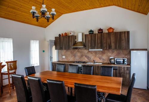 cocina con mesa de madera y nevera en Vendégház Harsány, en Harsány