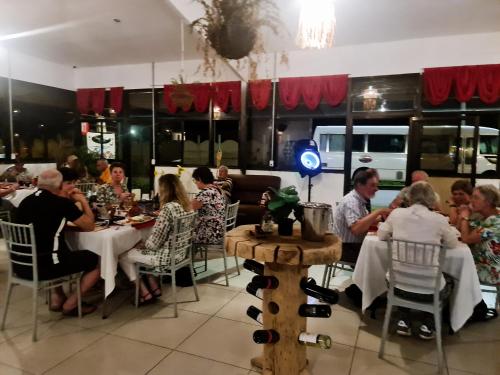 um grupo de pessoas sentadas em mesas em um restaurante em El Rincon em Cahuita