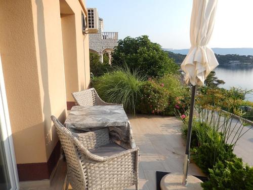 a patio with two chairs and a table and an umbrella at Apartments and rooms with WiFi Sobra, Mljet - 18465 in Babino Polje