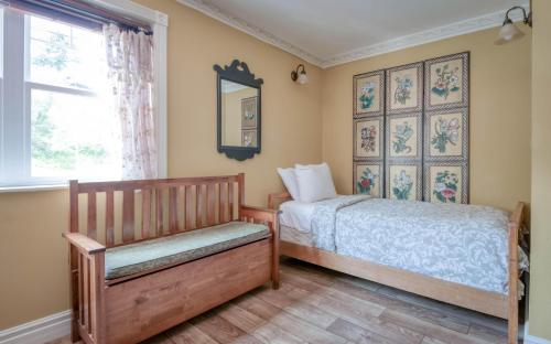 1 dormitorio con cama, banco y ventana en Bayfront History - Anchor Pier Lodge en Newport