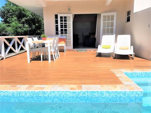a patio with a table and chairs next to a pool at Vacation Home with Private Pool in Jolly Harbour