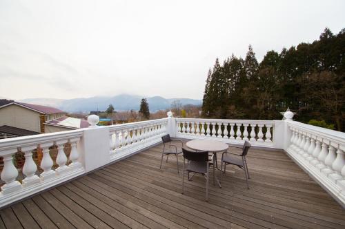 a balcony with a table and chairs on it at Yufuin Hotel Mori-no-Terrace in Yufuin