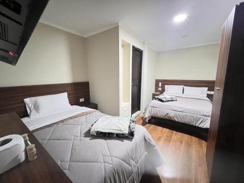 Habitación de hotel con 2 camas y TV en Ayña Hotel, en Chachapoyas