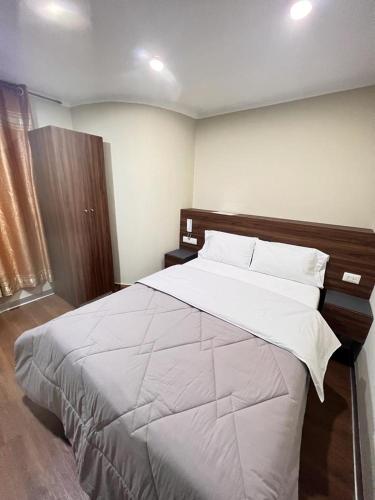 1 dormitorio con 1 cama grande con sábanas y almohadas blancas en Ayña Hotel, en Chachapoyas