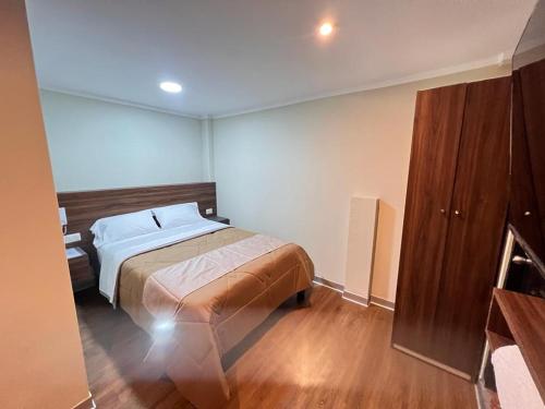 1 dormitorio con 1 cama y suelo de madera en Ayña Hotel, en Chachapoyas